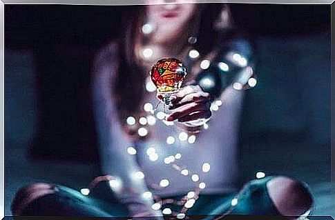 Woman holding colored light bulb