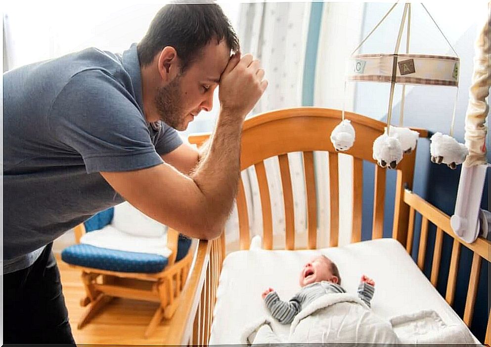 father with baby crying in the crib