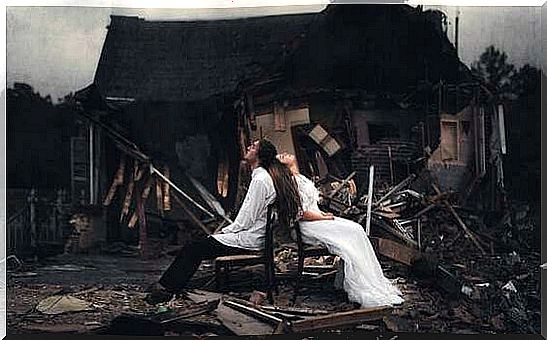 couple in front of a demolished-house