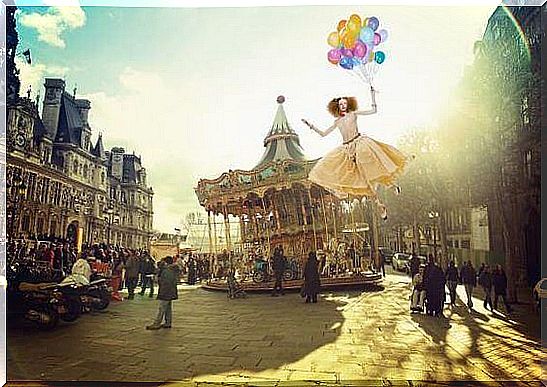 Carousel and woman flying holding balloons.