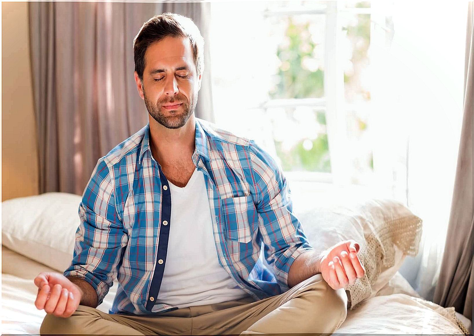 man meditating in bed