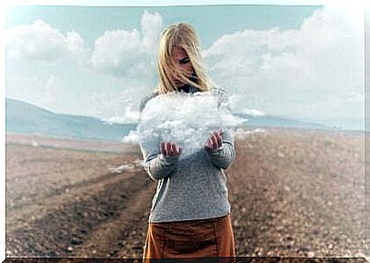 Woman holding a cloud in a desert.